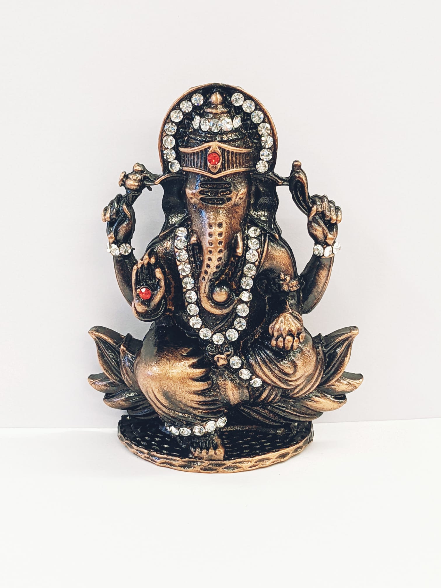 Image of a copper shaded Car dashboard Idol of Lord Ganesha