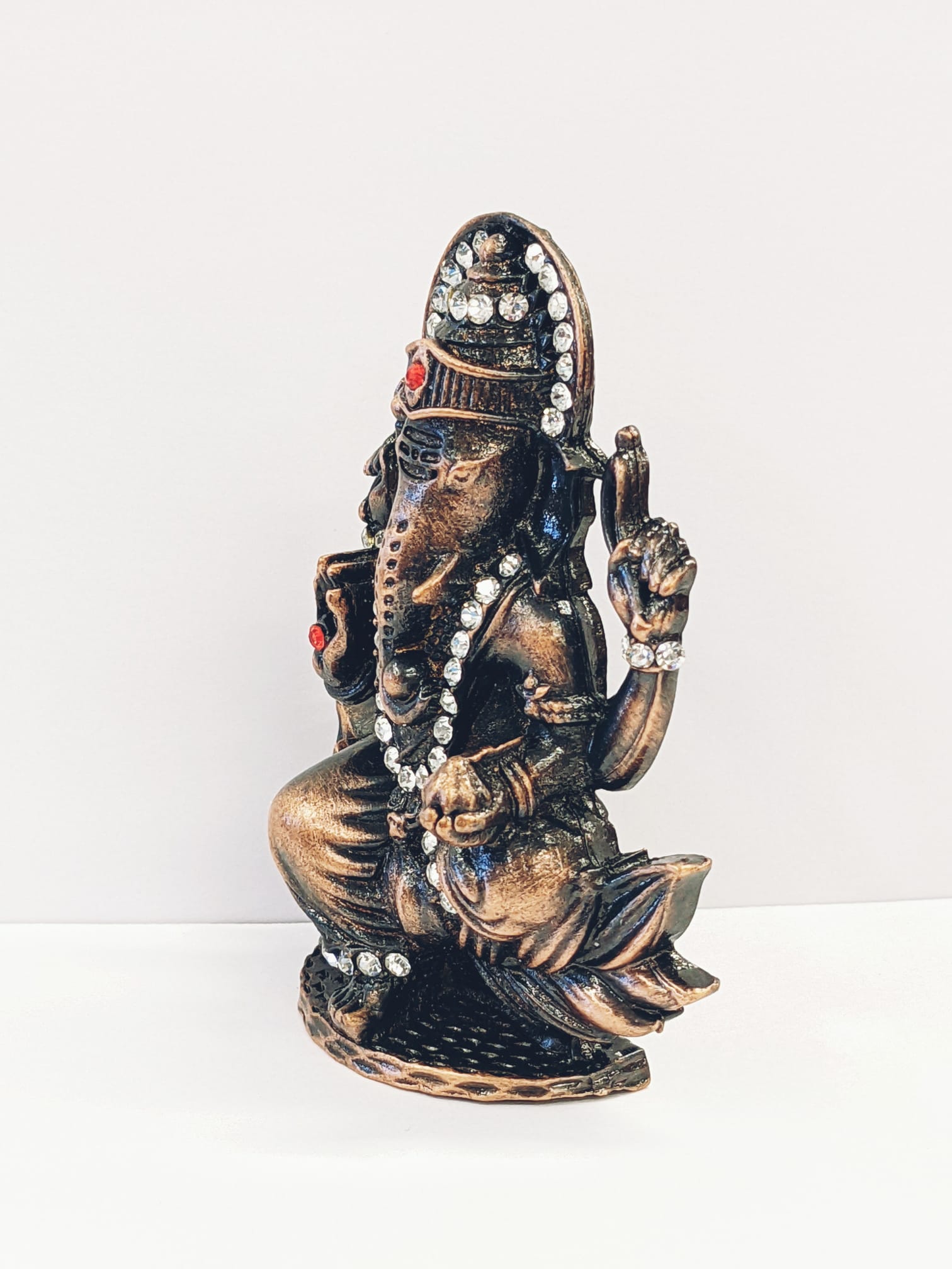 Image of a copper shaded Car dashboard Idol of Lord Ganesha with stone work
