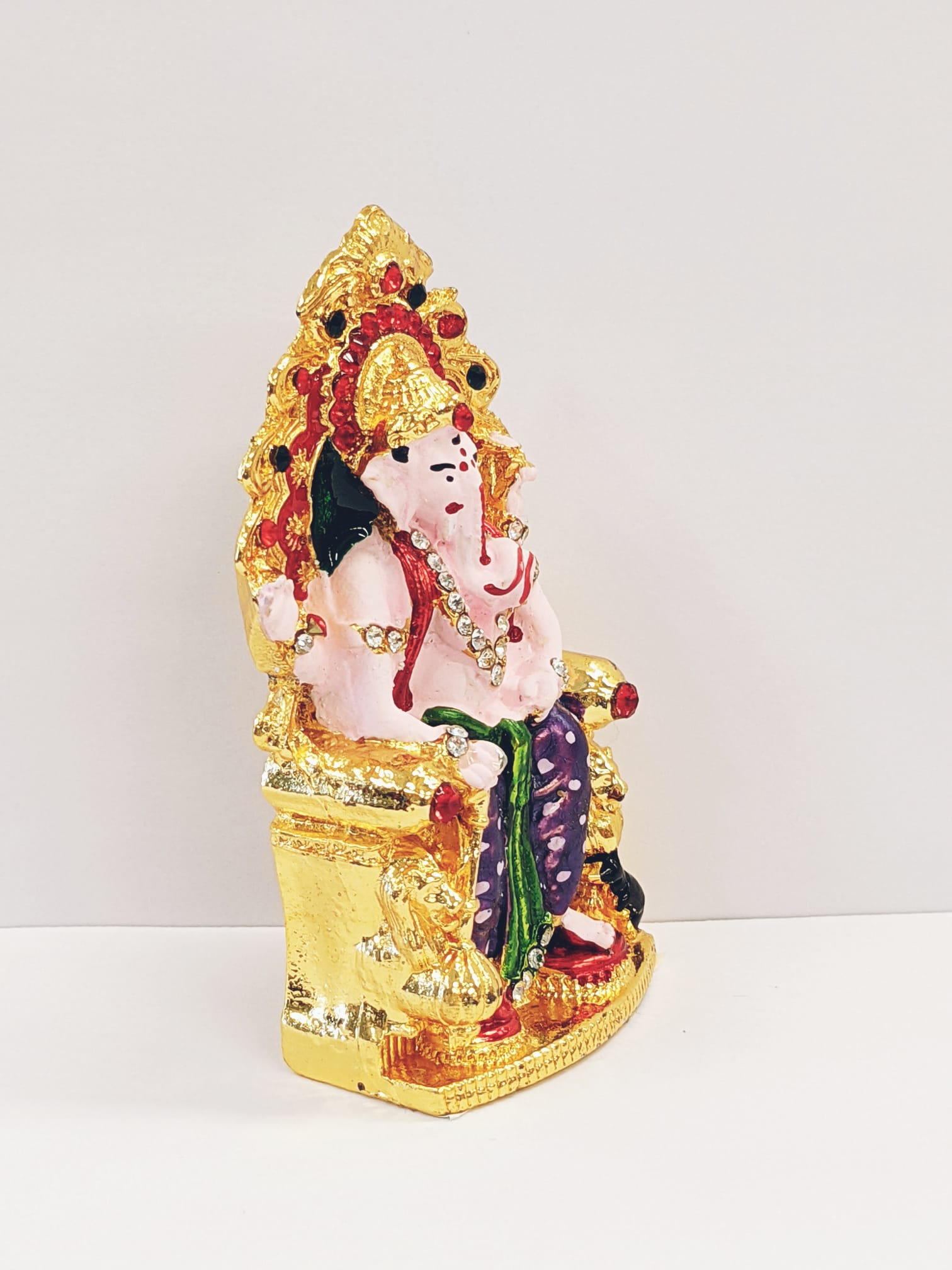 side view Image of a Car dashboard Idol of Ganesha sitting on a throne