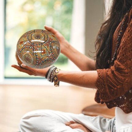 Image of a yoga performer holding the 9 inch tongue drum for meditation