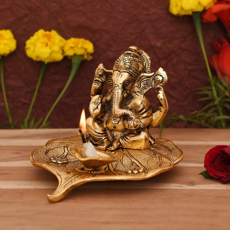 Ganesha on Beetle leaf with a diya in front