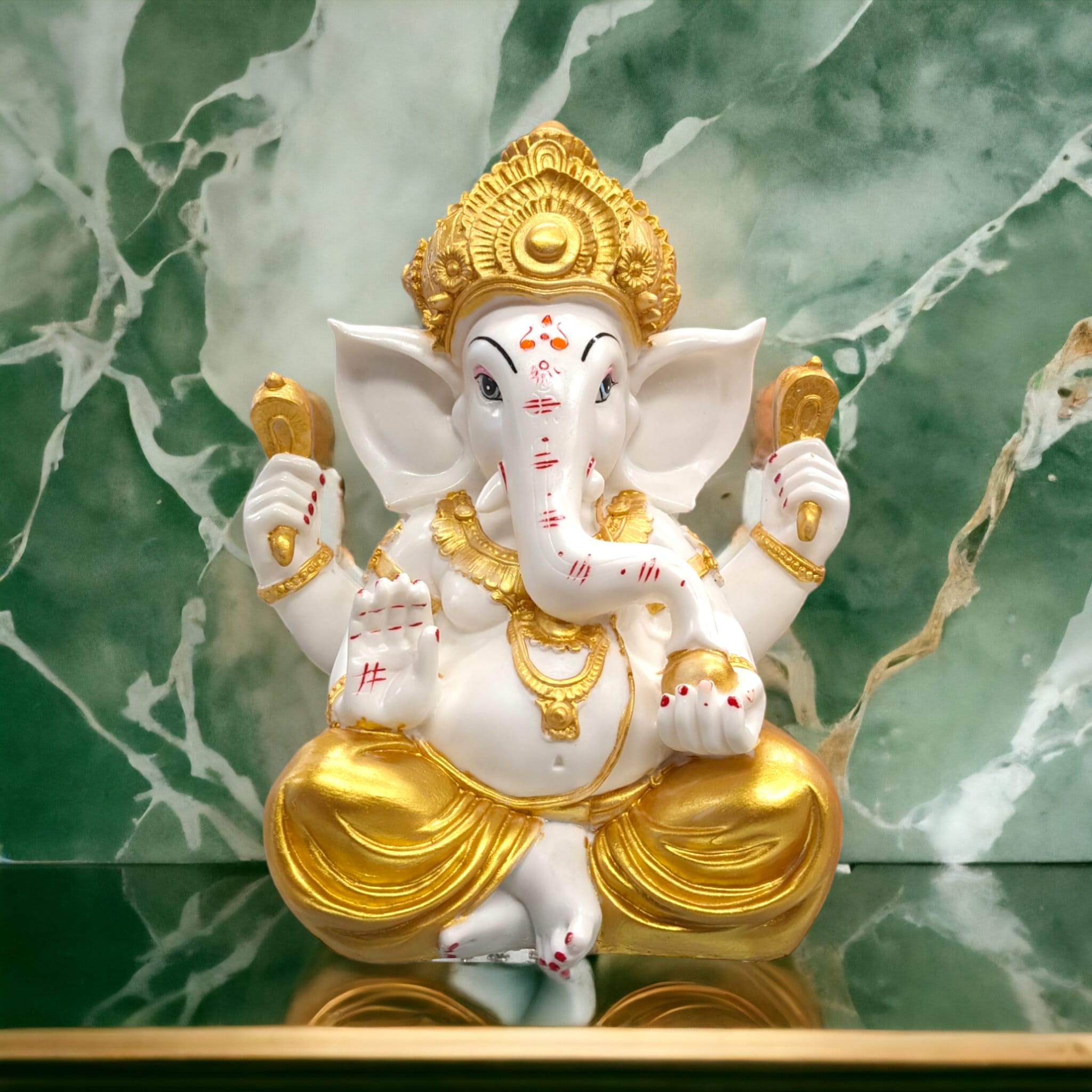 Image of Large sized Ganesh Idol with golden dhoti placed on a marble top