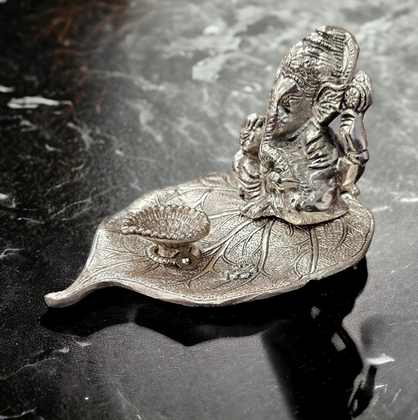 Ganesha on Beetle leaf with a diya in front - Silver