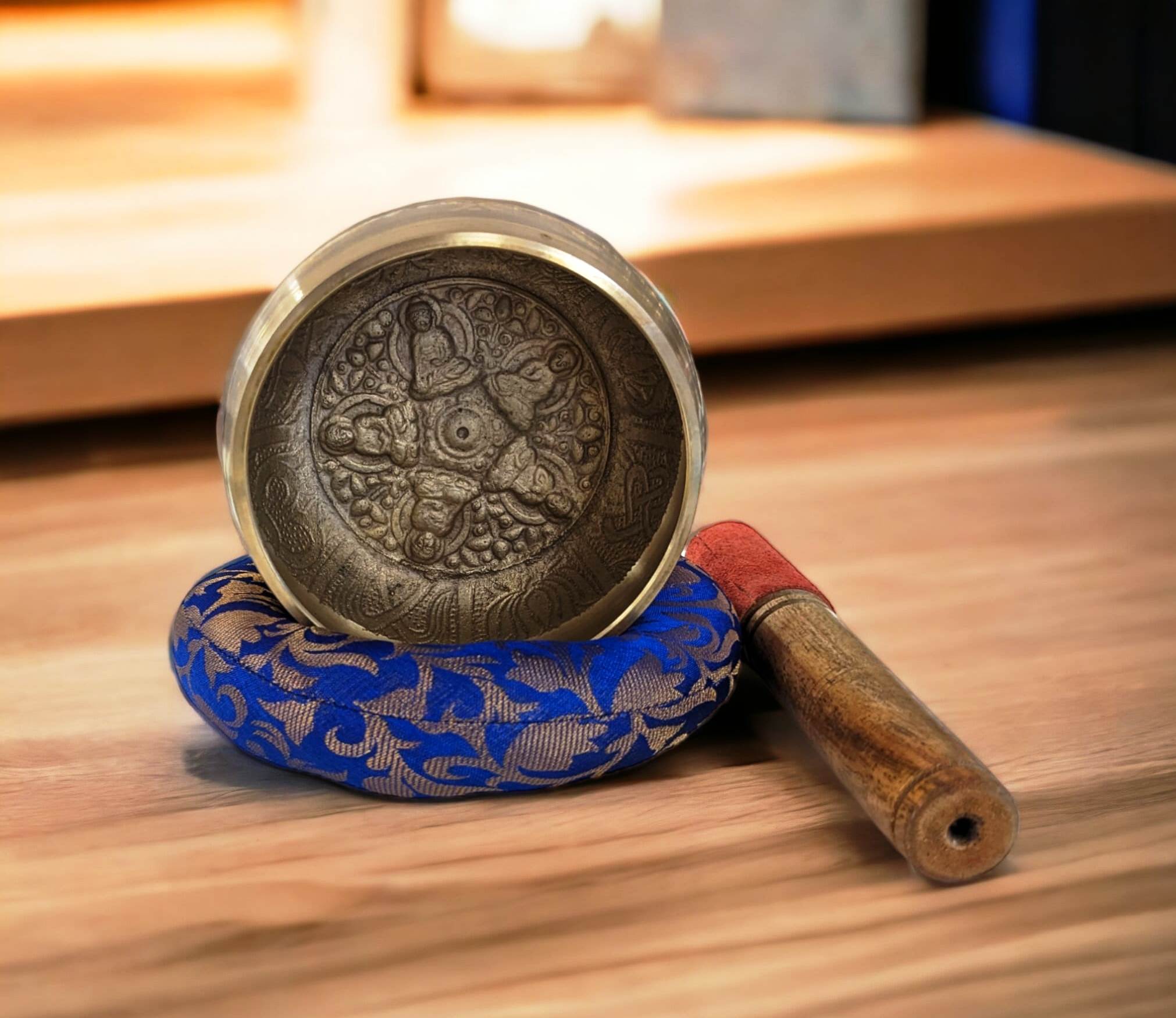Image of a 4.5 inches Tibetan Singing bowl with a wooden mallet placed on a Cushion Cover