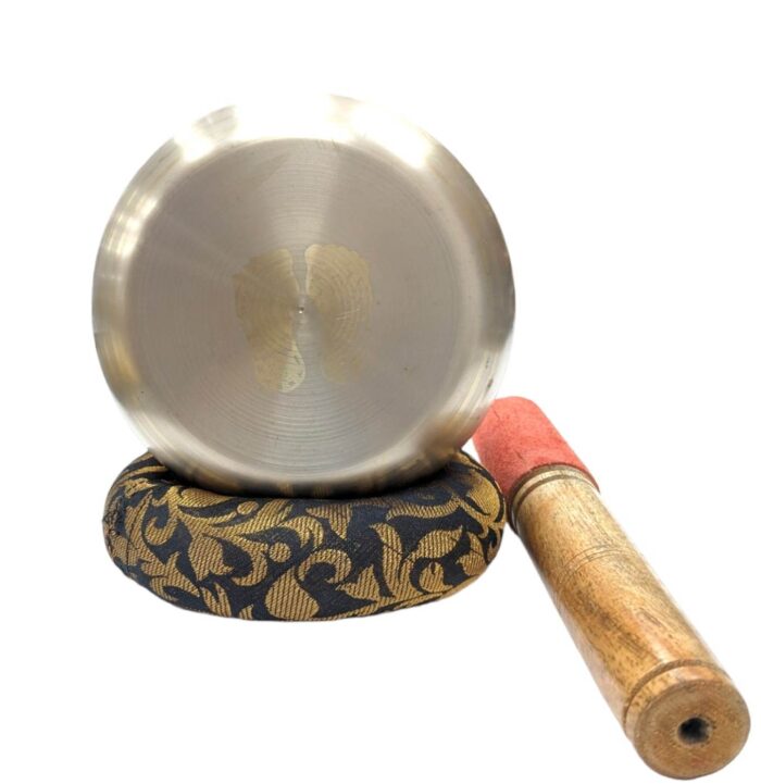 Image of a 4.5 inches Tibetan Singing bowl with a wooden mallet placed on a Cushion Cover