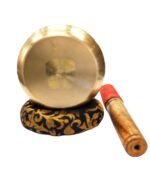 Image of a Tibetan Singing bowl with a wooden mallet placed on a Cushion Cover