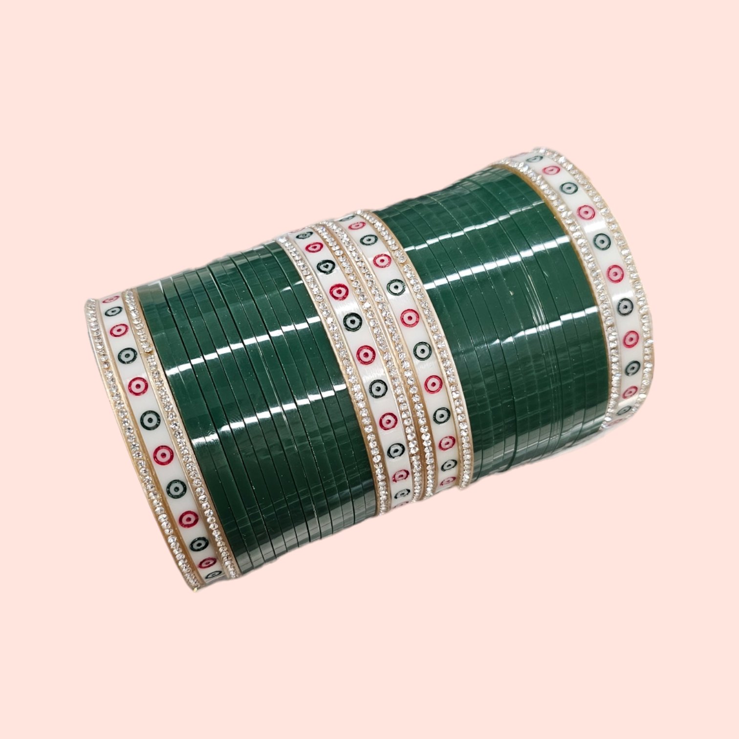 Green Chura with silver gemstones on a pink embroidered background.