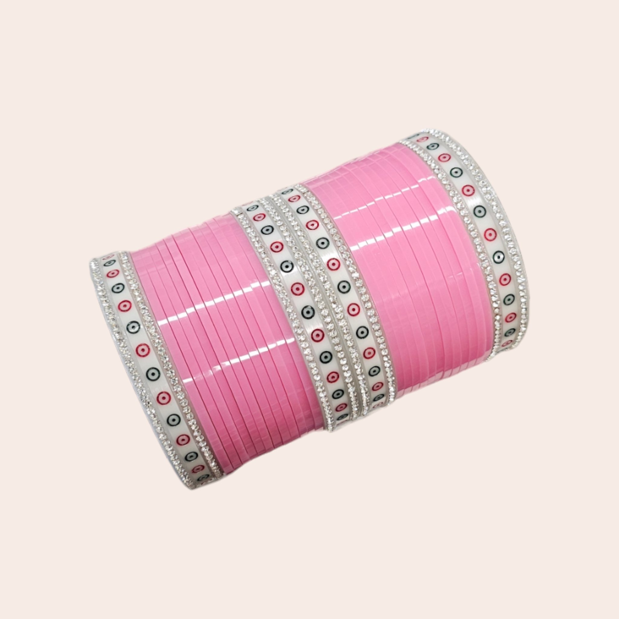 Pink colored Chura with silver gemstones on a pink embroidered background.