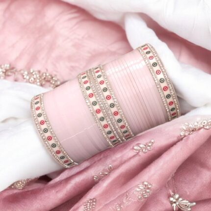 Litchi/Pale Pink colored Chura with silver gemstones on a pink embroidered background.