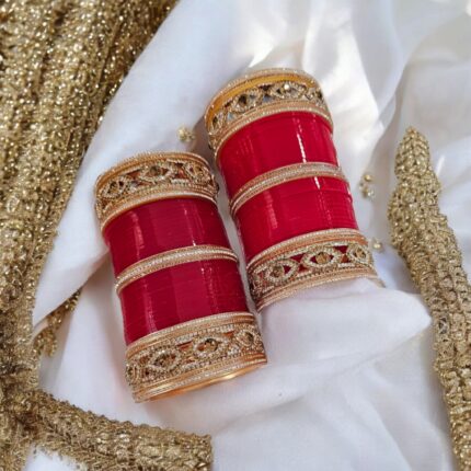 Designer Red Chura with silver gemstones and evil eyes on an embroidered scarf as the background.