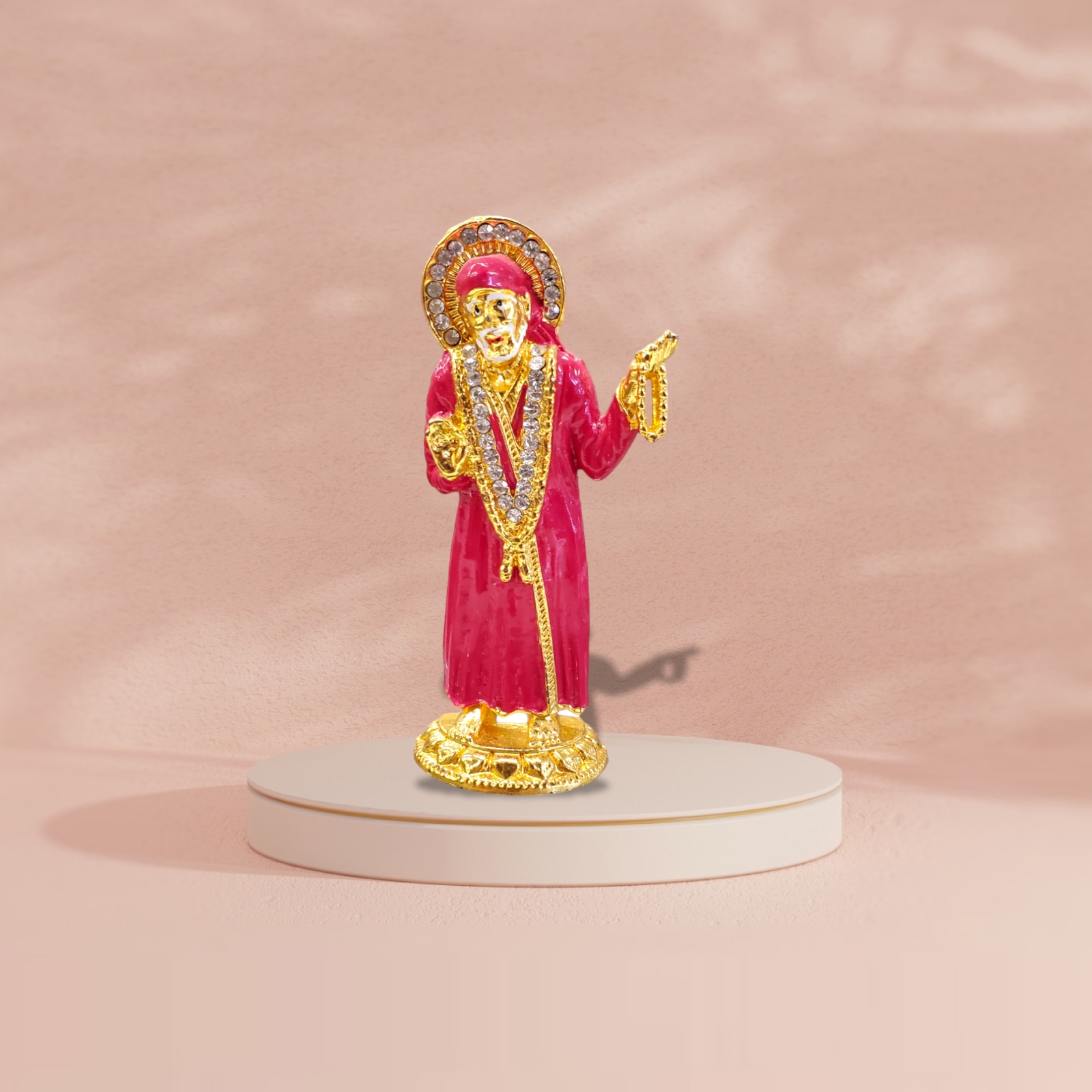 Buy Sai Baba car dashboard idol in Canada and US. Red Sai Baba idol on a pink background.