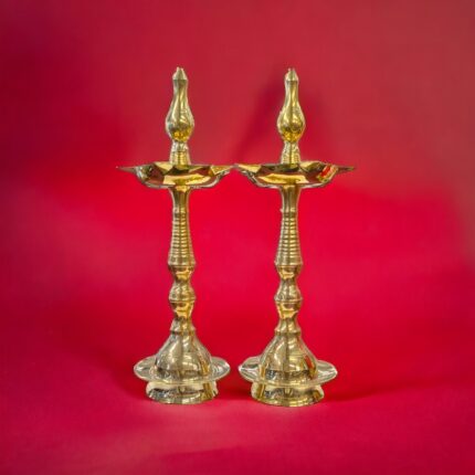 Image of pure Brass Kerala lamps placed on a red background. For sale in Canada and the US