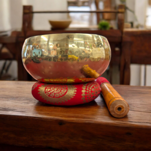 Image of Hammered Brass singing bowl placed on a cushion with wooden mallet , available for sale in Canada and the US