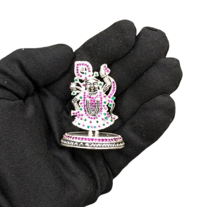 Real look of the Pure Silver Krishna Idol with embedded stones on an adult hand