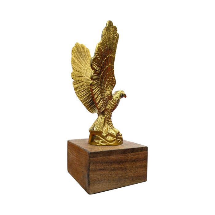 Profile view of a soaring brass eagle statue showcasing its wide wingspan on a wood stand.