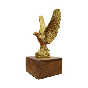 Profile view of a soaring brass eagle statue showcasing its wide wingspan on a wood stand.