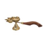 Close up of wooden handle connected to Brass panch deepam