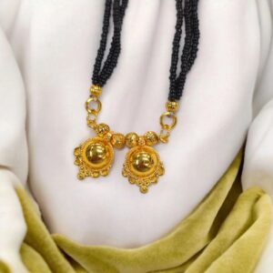 Two Wati Mangalsutra necklace with gold plating and black bead chain, laid flat on a white velvet pad.