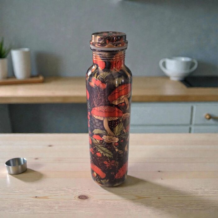 Artisan-made copper water bottle from India, shown on a wooden table in a kitchen.