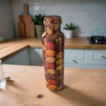 Pure copper water bottle from India, shown on a wooden table.