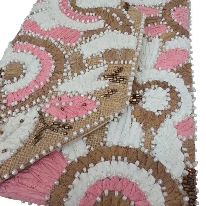 Close-up of floral embroidery on pink boho clutch